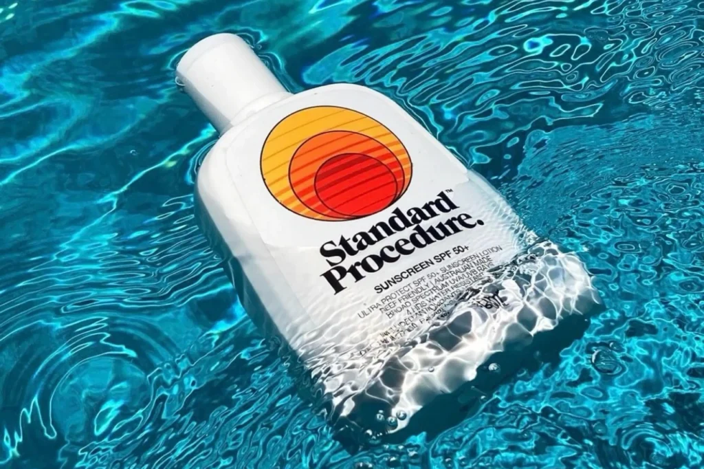 Next-Gen SPF: 7 Proven Benefits for Superior Tropical Skin Protection in 2026 4 A white Standard Procedure SPF 50 sunscreen bottle floating in clear blue water highlighting its water resistant feature