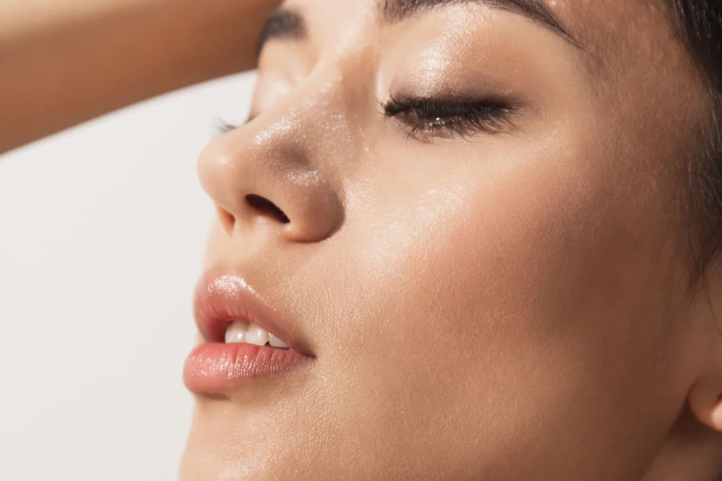 Close-up of a woman's smooth, glowing skin with eyes closed, highlighting healthy collagen-rich texture.